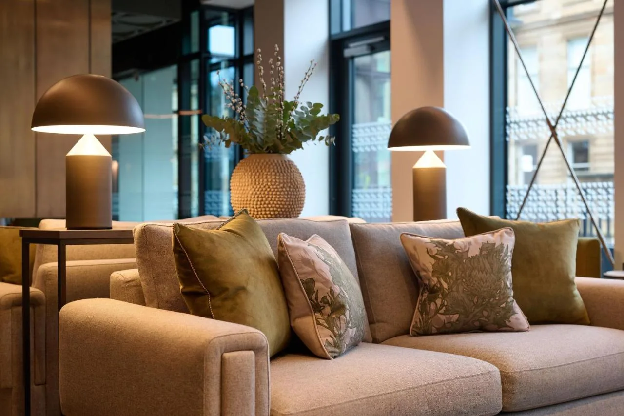 a couch with pillows in a room with windows at The Resident Edinburgh in Edinburgh